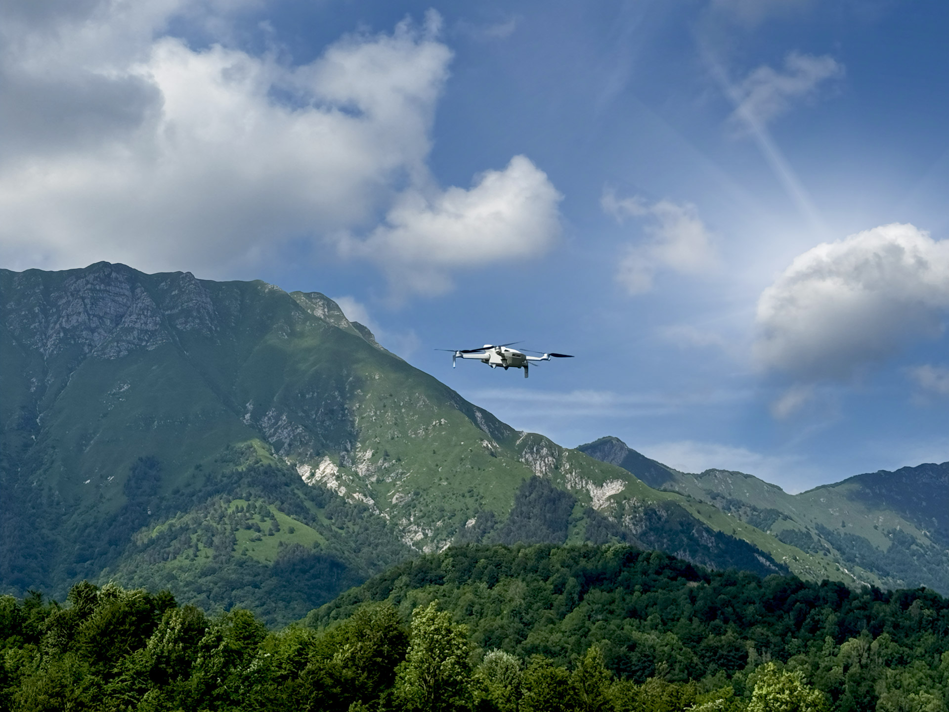 Drone ripreso nel momento del volo con sfondo delle montagne in lontananza