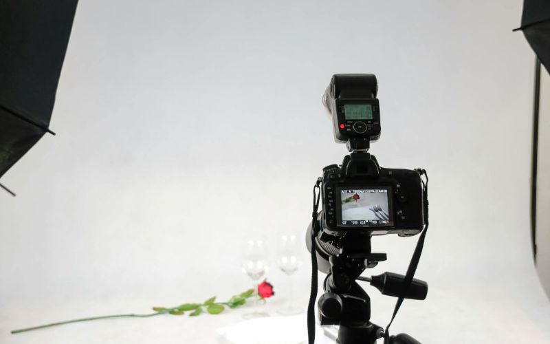 Macchina fotografica su piedistallo con foto set